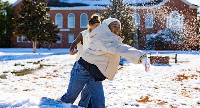 A girl throws a snowball in front of Stephens Hall following the historic 2025 blizzard.
