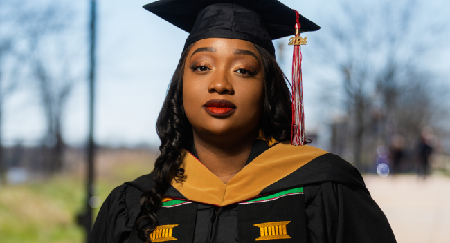 UL Lafayette online MBA grad poses in black graduation regalia. 