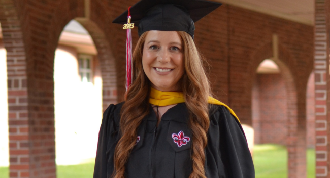 Tori Miguez, graduate of the masters in informatics online program, poses for a cap & gown photo on UL Lafayette's campus.