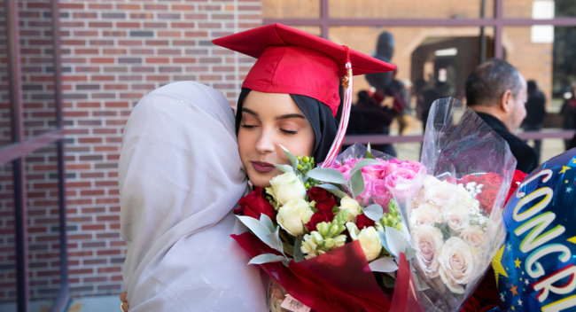 Haneen Muthana hugs family member outside the Cajundome after commencement ceremonies.