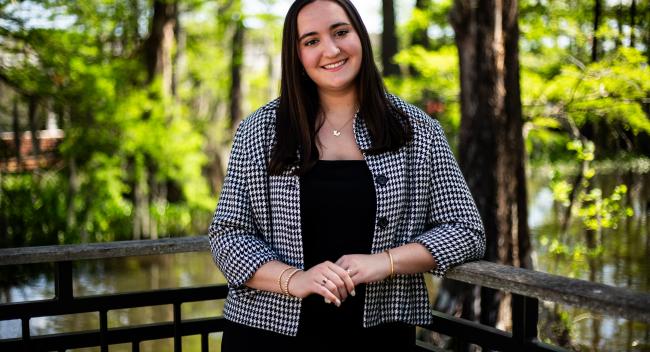 A professional portrait photo of Camille Brown in front of a lake on campus at the University of Louisiana at Lafayette.