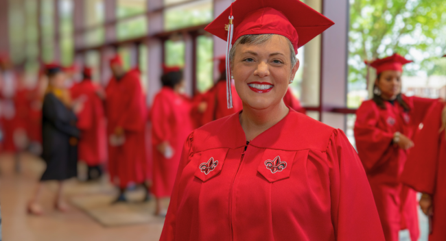 Sommer Haas, alumna of UL Lafayette's online bachelor's program in general studies, smiles for a portrait in her cap and gown before graduation.