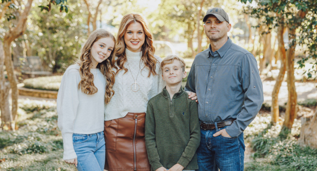Alumni of the online master's in informatics program smiles with her husband, son, and daughter. 
