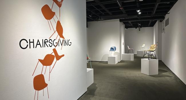 Entrance into the College of the Arts Fletcher Hall Gallery with Chairsgiving logo on the wall.