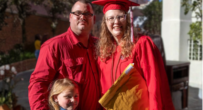 Online health and wellness student smiles with family at UL Lafayette's Commencement..