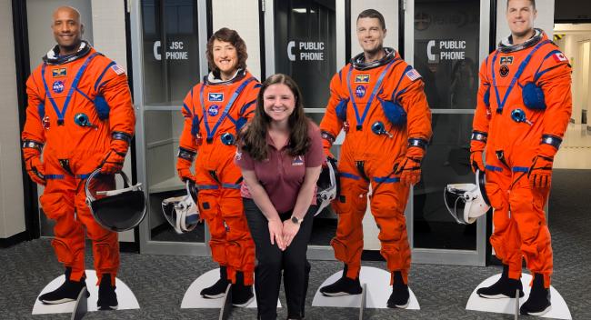 UL Lafayette grad with cutouts of Artemis astronauts