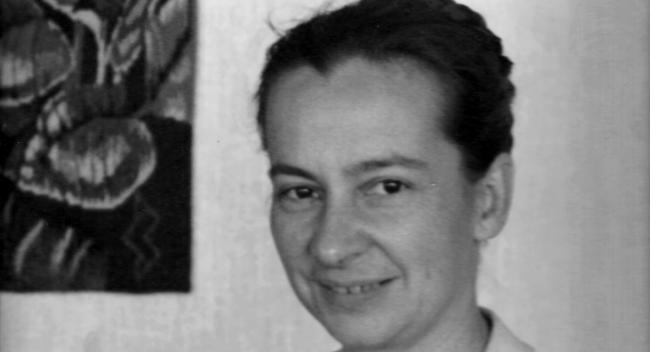 Black and white portrait of middle-aged woman with her hair pulled back in a bun.