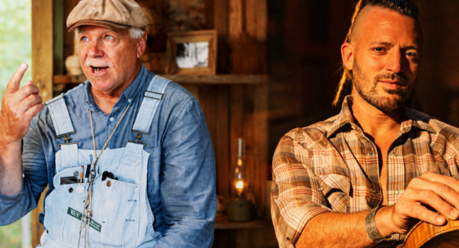 Two men sitting in a living room. One hands a fiddle, the other wears a duck call around his neck.