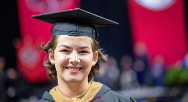 M.S. in Accounting graduate Debra Crawford smiles during commencement ceremonies. She's wearing black, UL Lafayette commencement regalia.