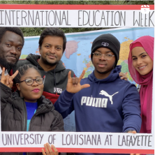 A diverse group of students pose inside a frame that says International Education Week across the top.