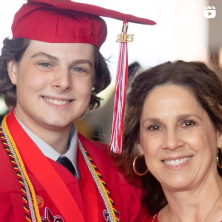 A white male UL Lafayette graduate in red cap and gown with his mother, an older white female.