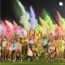 UL Students covered in colored powder at night.