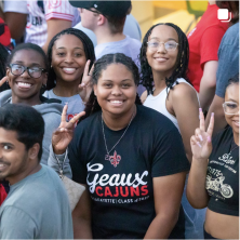 A group of UL Students smiling and holding up peace signs.