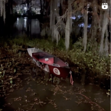A lone canoe sitting in the UL Swamp at night.