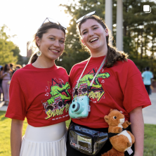 Two women wearing red swamp party shirts smiling together