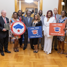 A group of people with "I am trio, Upward Bound" signs in formal wear