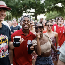 A group of student with drinks in a crowd