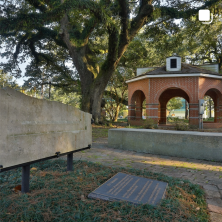 a scenic photo of a gazebo under trees