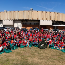 A large group of students holding up trash bags before the cleanup