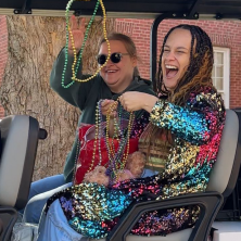 People throwing mardi gras beads off of a golf cart