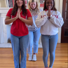 A group of girls calsping their hands as if in prayer