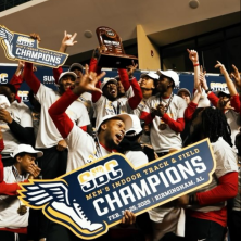 A group of atheletes holding a Men's Indoor Track and Field Champions sign