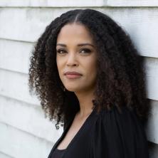 Headshot of Author, Jesmyn Ward, leaning on a building
