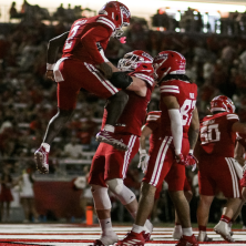 Four football students jump in victory