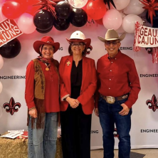 Three UL instructors with country hats pose in a line