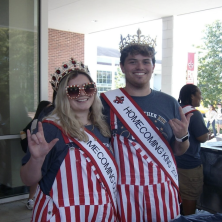 UL Homecoming Queen and King pose at the camera with the UL Sign