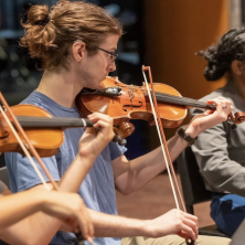 UL student looks at instructor while playing the fiddle