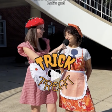 Two UL students dresses as Strawberry Shortcake and Orange Blossom pose behind a "Trick or Treat" logo