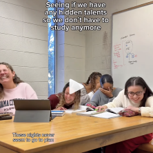 Five UL students laugh at a desk while trying to sing