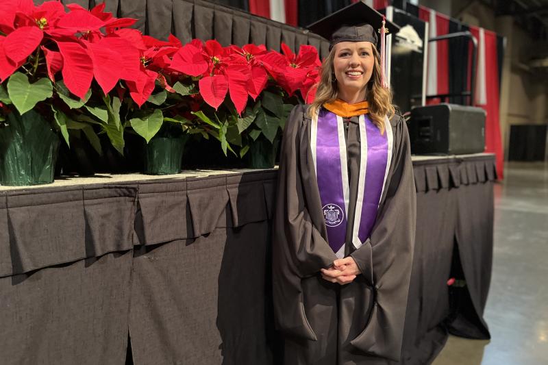 Dana Wallis stands near the commencement stage at the Cajundome Convention Center ahead of Fall 2023 graduation.