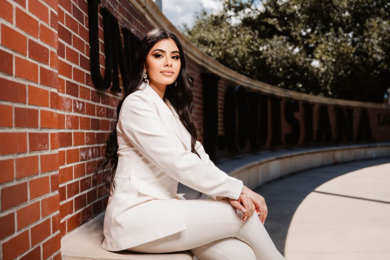 Tala Tobeh sits in front of the UL Lafayette wall. Tala earned her degree in criminal justice before taking a job with the state's fusion office.