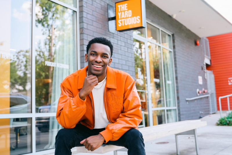 Online general studies grad Cameron Theyard smiles in front of his office space, The Yard Studios.