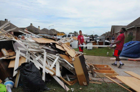 Ragin' Cajuns football players and staff help flood victims clear out damaged houses in flood-affected Youngsville.