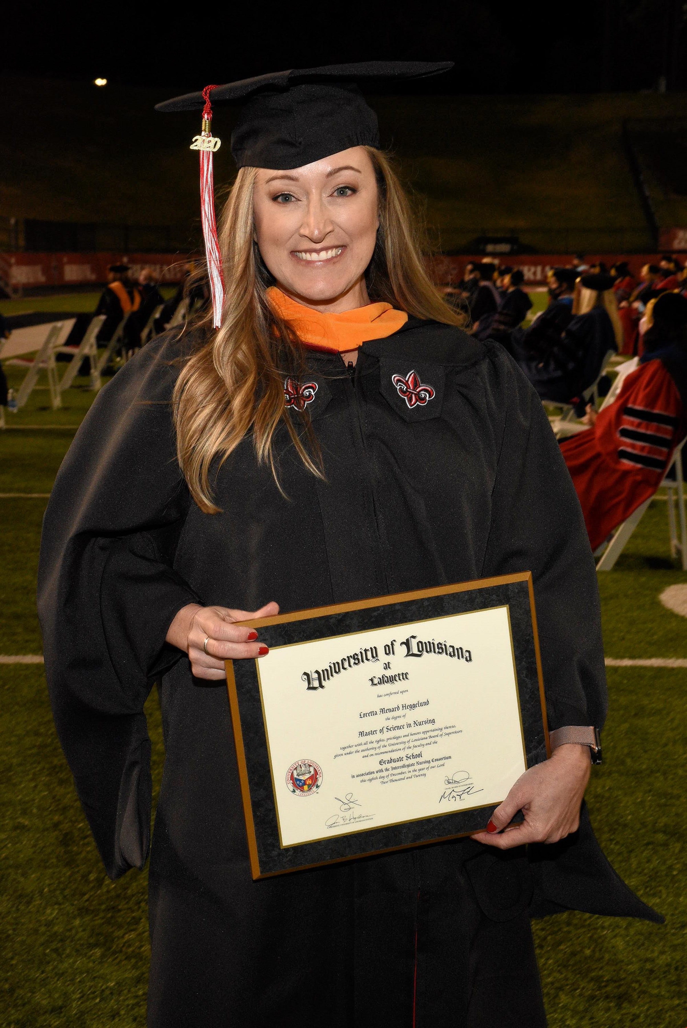 Loretta Heggelund holds her degree plague during Fall 2020 Commencement ceremonies upon completing her MSN online at UL Lafayette.