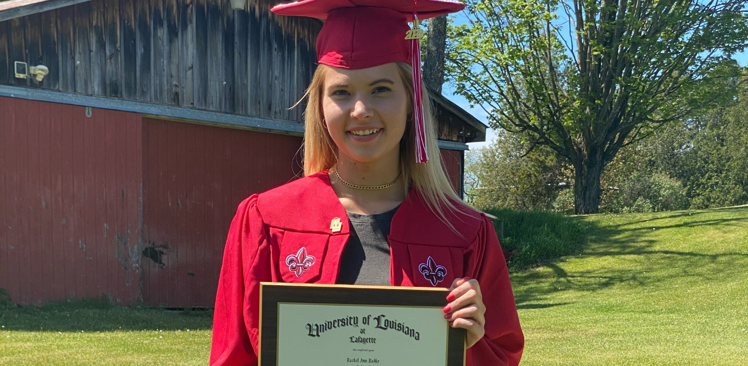 Rachel Radke, pictured in her red UL Lafayette commencement gown and mortarboard cap, earned her degree in Health Promotion and Wellness online.