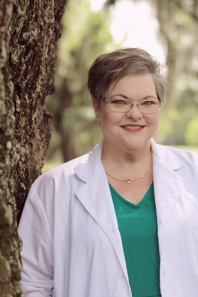 Tammy Bennett is pictured in a green shirt and white coat, characteristic of medical professionals