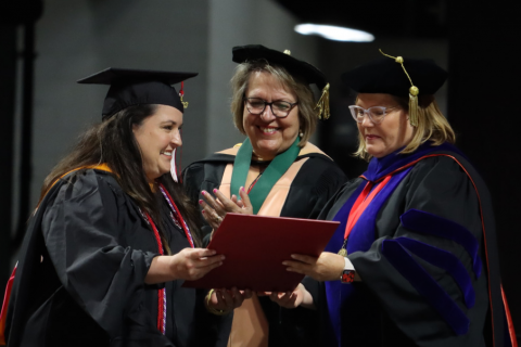 Drs. Melinda Oberleitner and Mary Farmer-Kaiser, dean of the Graduate School, award Crystal Smith with the outstanding master's graduate award.