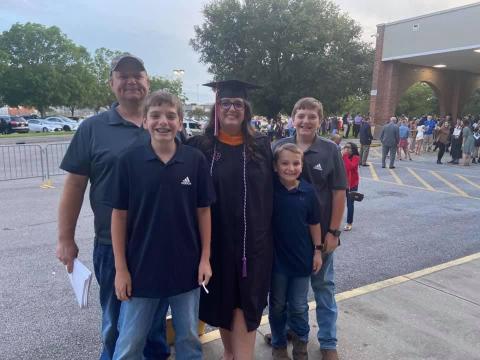 Kelly Bankston, UL Lafayette MSN graduate, stands with her husband and three sons outside of the Cajundome during commencement exercises.
