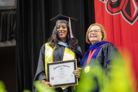 Rekeisha Triggs, M.Ed. in Educational Leadership graduate, accepts her degree from Dean Mary Farmer-Kaiser