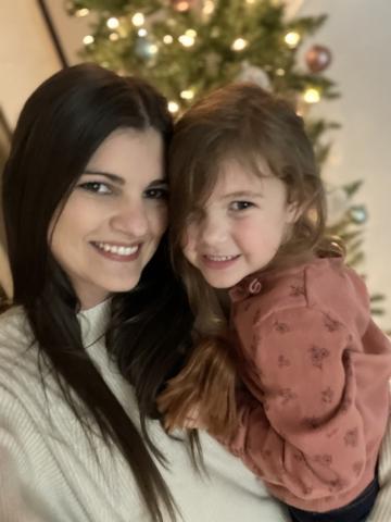 Teacher Robyn Pefferkorn pictured in front of a Christmas tree with her 4-year-old daughter