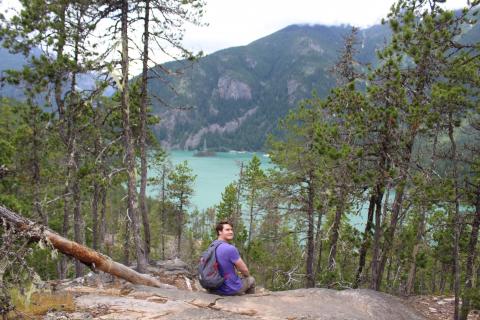 Samuel Hacker, MBA, sits at an overlook near Diablo Lake, Washington. 