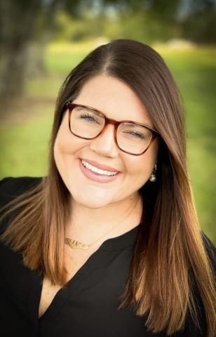 Addie Snyder pictured outdoors, smiling. Addie is a psychiatric mental health nurse practitioner in Lafayette Parish